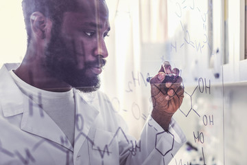 Chemist holding marker pen writing molecular formula