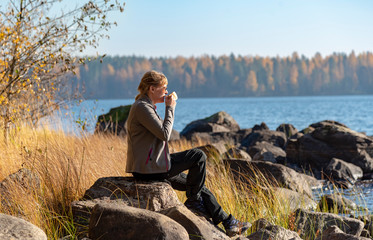 Woman sitting on the lake shore