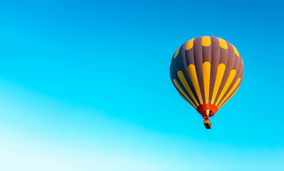 Naklejka premium Colorful hot air balloon isolated on blue sky background. Colorful hot air balloon flying over at fairy chimneys in Nevsehir, Goreme, Cappadocia Turkey. 
