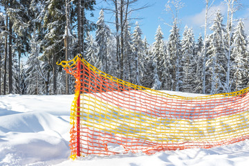 Ski resort Bukovel. Ukrainian Carpathians. Safety fence for security. Multicolored mesh to attract attention. The rules of skiing and snowboarding. Warning of danger. Winter landscape.