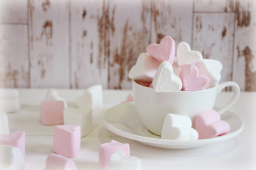 Sweet marshmallows in the shape of heart in the ceramic cup with pink background. Concept about love and relationship. Romantic Style, Creative for colorful greeting card. Valentines day background he