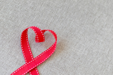 Heart made from red ribbon on linen textile with space for text, Valentine's Day concept.