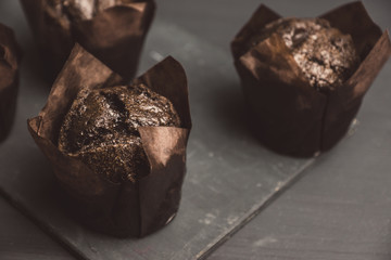 Freshly baked chocolate muffins on the rustic background. Selective focus. Shalow depth of field.