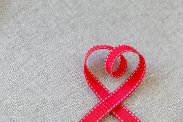 Heart made from red ribbon on linen textile with space for text, Valentine's Day concept.