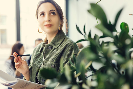 Woman Stand At Office Surround With Green Plants And Write At Her Note Book