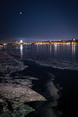 night view of riddarfjärden in stockholm at winter with blood moon in sky