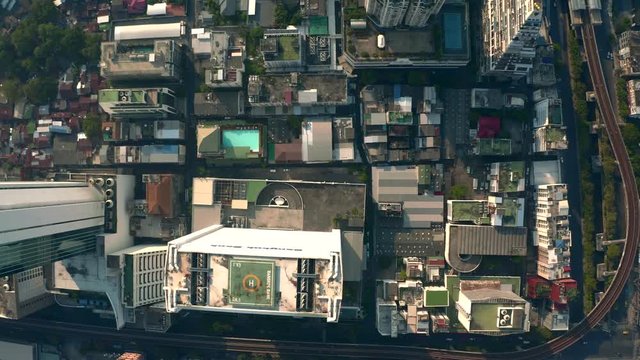 Aerial city view of Bangkok with crossroads and roads, houses, buildings and parking lots. Helicopter drone shot.