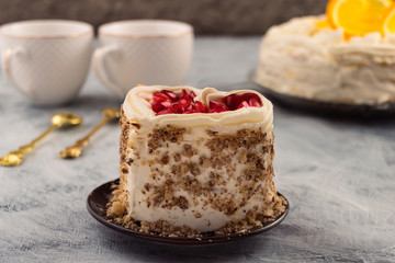 Portion of a festive cake on a round plate. Ground nut and pomegranate grains to decorate the dessert.