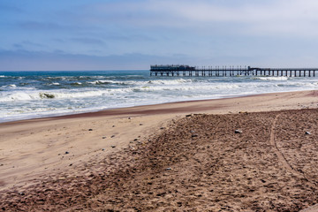 Silhouette of the historic jetty and anglers against the setting sun, in Swakopmund inon the Atlantic Coast of Namibia
