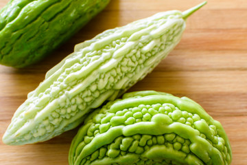 fresh bitter melons on wooden board
