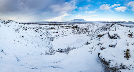 Panoramic view of the Kerid Volcano  Iceland with snow and ice in the volcanic crater lake in Winter under a blue sky