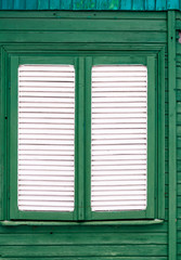 Full frame shot of shutter of old white timber window on green  wooden building