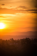 Fototapeta na wymiar Hazy colorful mountain sunrise in Redding California, with orange, red and yellow colors