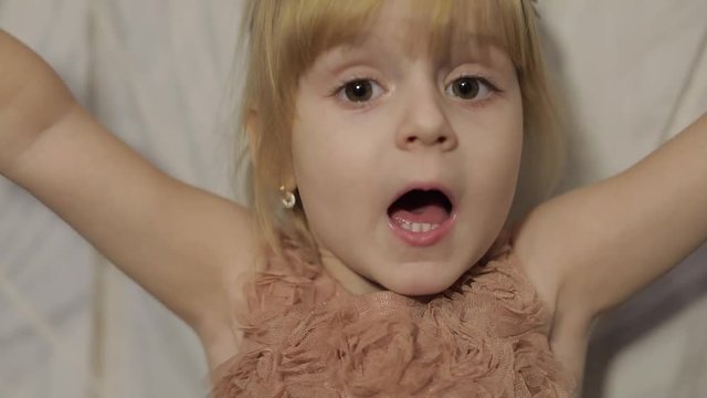 Happy three years old girl make faces and dancing. Cute blonde child. Brown eyes. Cute girl smiling. Pretty little child, 3-4 year old blonde girl