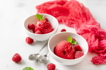 Raspberry sorbet in two cups on white table