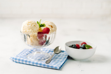 Vanilla ice cream with berries on white background