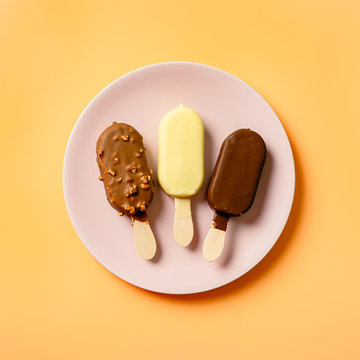 Square Shot Of Three Ice Cream Popsicles In Pink Plate