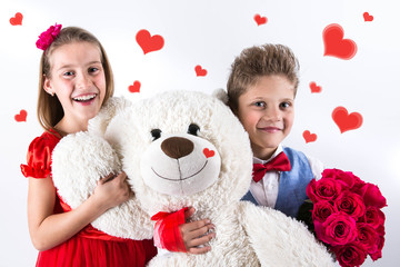 Pretty little girl and boy  celebrating Saint Valentine's Day and holding red roses bucket  and white bear gift on the white background with red hearts