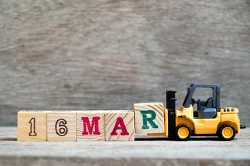 Toy forklift hold block R to complete word 16mar on wood background (Concept for calendar date 16 in month March)