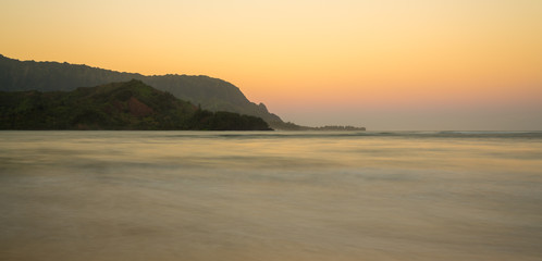 Sunrise lights the dawn sky above Hanalei Bay with the Na Pali coast in the background near Hanalei, Kauai, Hawaii