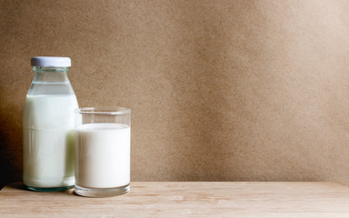 A bottle of milk with glass on the wooden table. Copy space for your text or image.