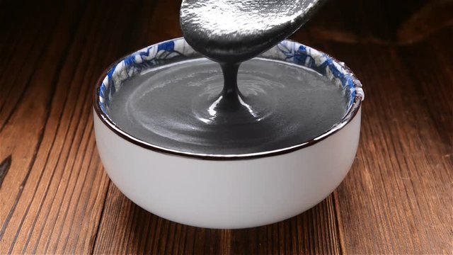 spoon taking out black sesame paste