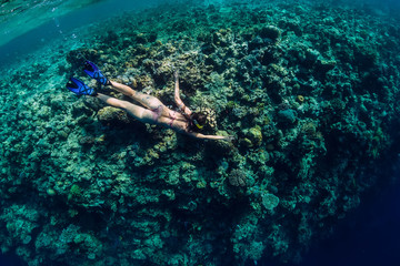 Woman in bikini dive in tropical ocean