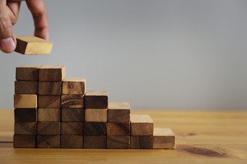 Closer up hands of businessmen,stacking wooden blocks into steps,Concept of business growth success - image