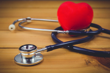 Close up red heart and steythoscope on old wood table and world health day and healthcare technology concept, vintage tone - Image
