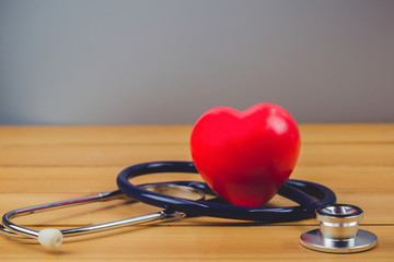 Close up red heart and steythoscope on old wood table and world health day and healthcare...