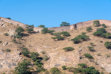 The long wall on the mountain of Amber fort in historical city of Amer, Jaipur, Rajasthan, India