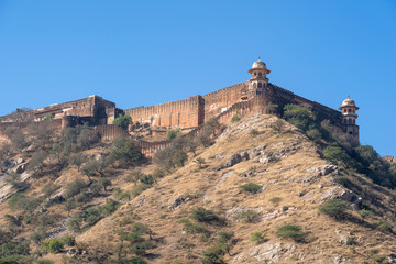 Fototapeta na wymiar The long wall on the mountain of Amber fort in historical city of Amer, Jaipur, Rajasthan, India
