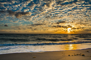 Cloudscape as the sun's beams spread over the horizon of a Florida Beach