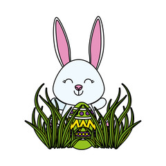 cute rabbit with easter egg painted in the meadow