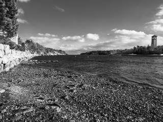 winter landscape with ice on rock shore and clouds