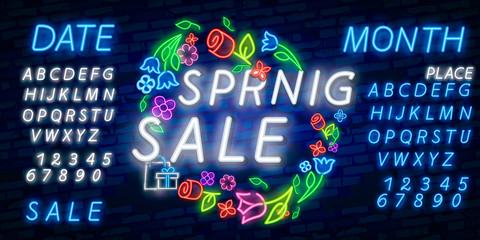 Neon alphabet and Spring Sale in flower frame over brick background. Spring sale, seasonal goods, store emblem. Spring concept. For signboards, template design, banners