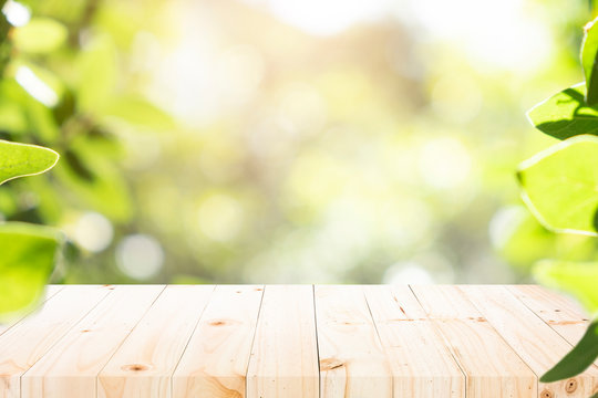 Wooden table with blur background of green bokeh.
