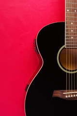 Acoustic guitar on red background
