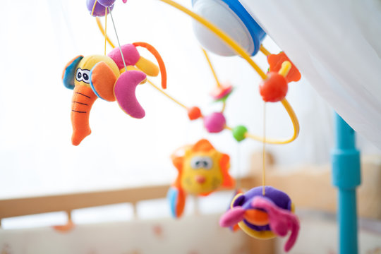 children's mobile over the bed, spinning carousel with toys. baby bedroom close up element. device for better baby sleep