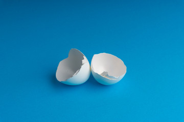 Broken eggshell on the blue background with selective focus