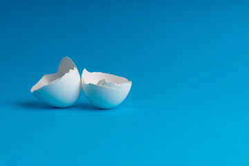 Broken eggshell on the blue background with selective focus