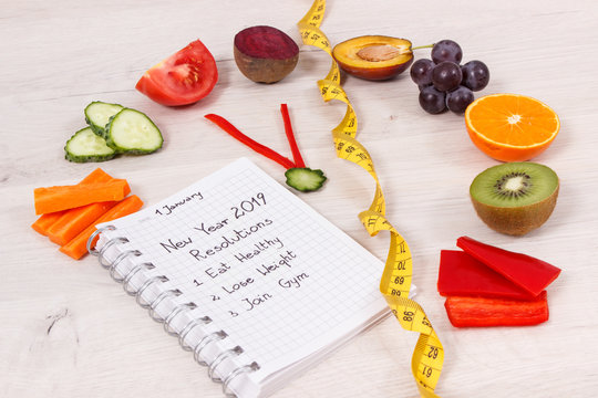 Goals for new year 2019 in notepad and fruits with vegetables in shape of clock
