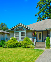 A perfect neighbourhood. Main entrance of nice residential house with green lash lawn on the front...