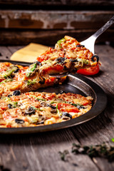 Concept of Italian cuisine, Homemade Italian pizza with salami sausage, tomatoes, with black olives and cheese on a wooden background. copy space
