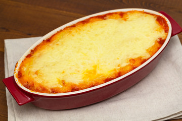 Shepherd's pie, traditional dish with minced meat and mashed potato on wooden table