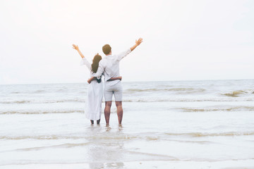 Happy couple going honeymoon travel on tropical sand beach in summer.