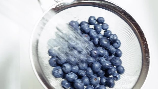 Tossing Blueberries Slow Motion Washing in Colander Under Sink Water