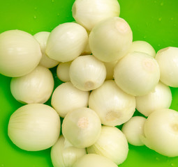Peeled onions on a green background