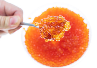 Spoon in red caviar on a white background