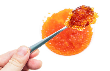 Spoon in red caviar on a white background